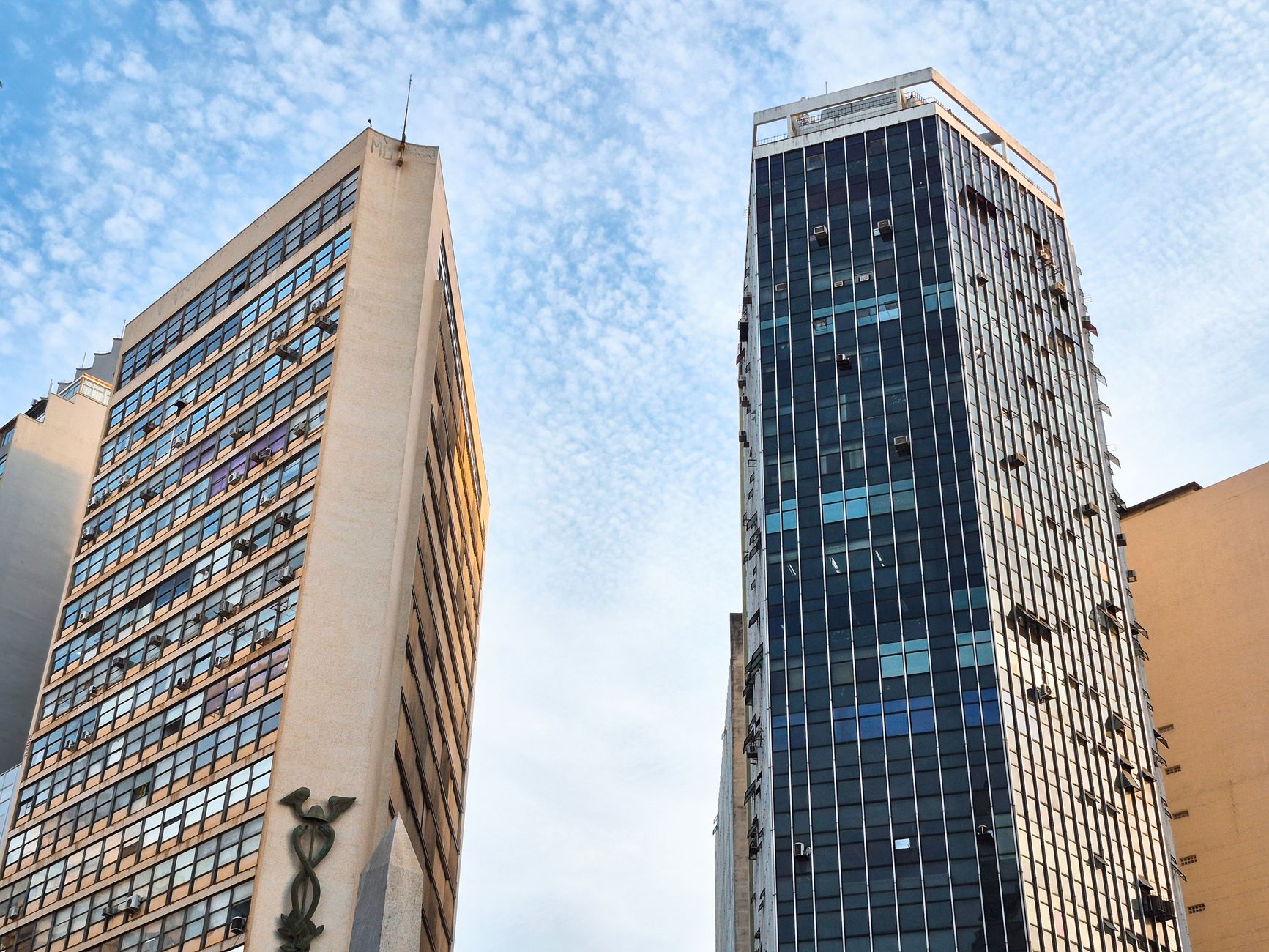 Altos arranha-céus urbanos com fundo de céu azul capturando a arquitetura moderna da cidade.