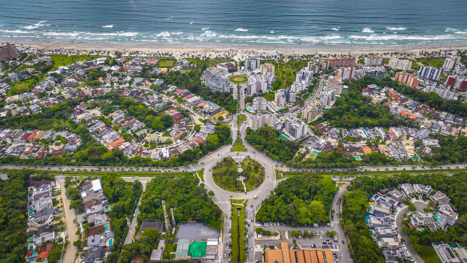 Foto aérea impressionante de uma cidade costeira exibindo vegetação exuberante e arquitetura complexa.