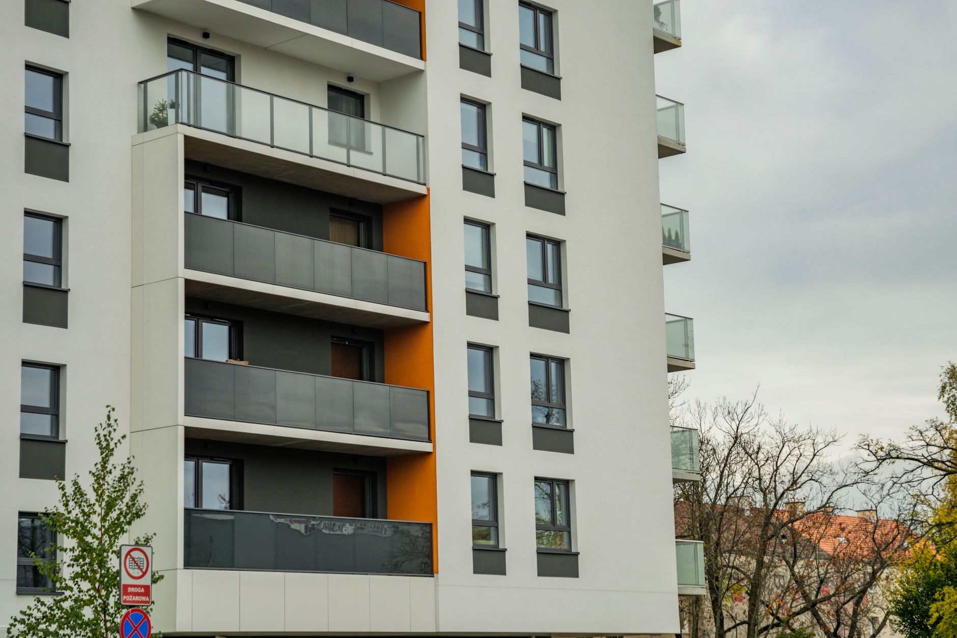 Fachada de edifício de apartamentos contemporâneo com varandas em um dia nublado.