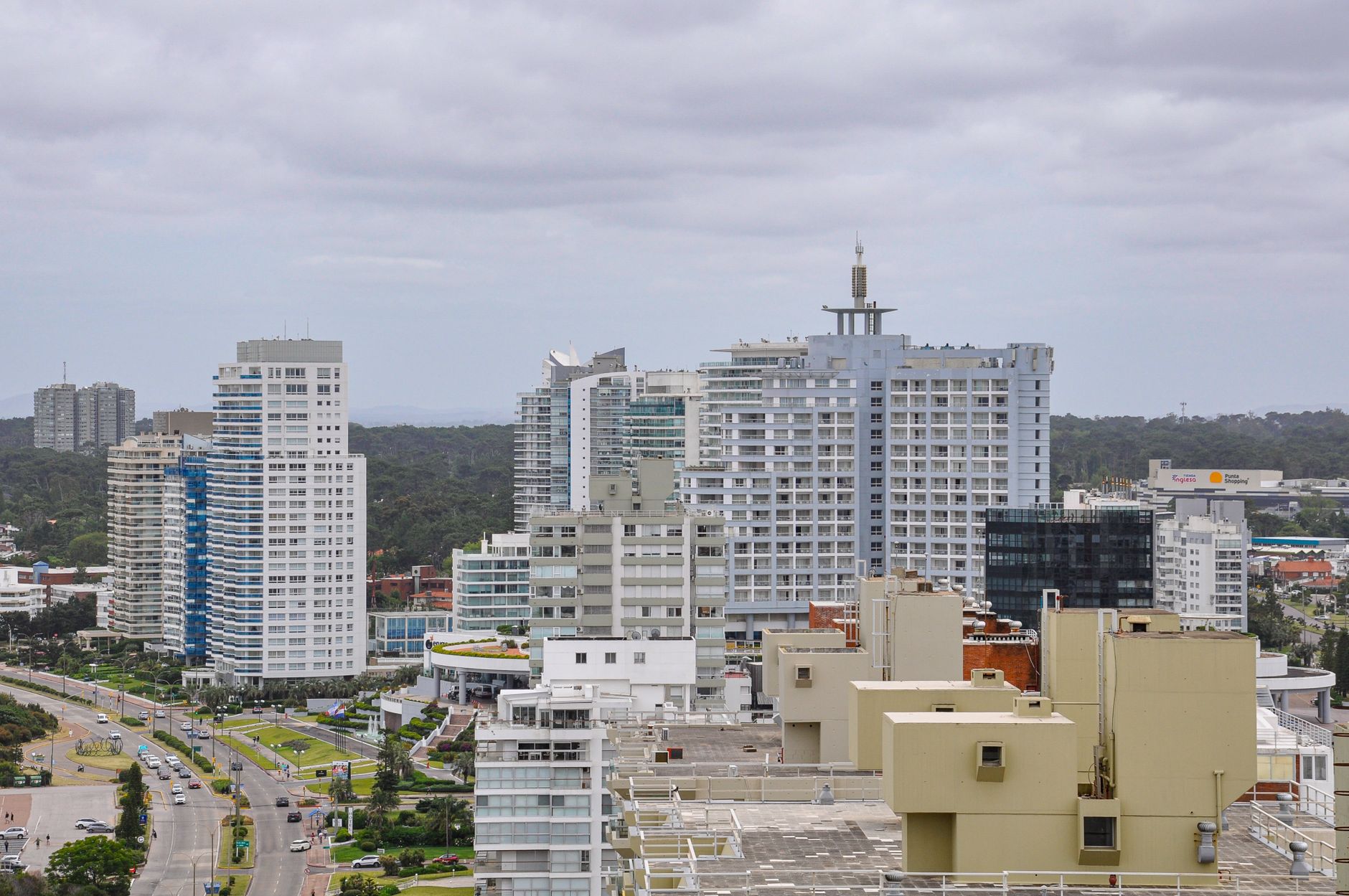 Vista aérea do horizonte moderno de Punta del Este, com seus altos edifícios sob um céu nublado.