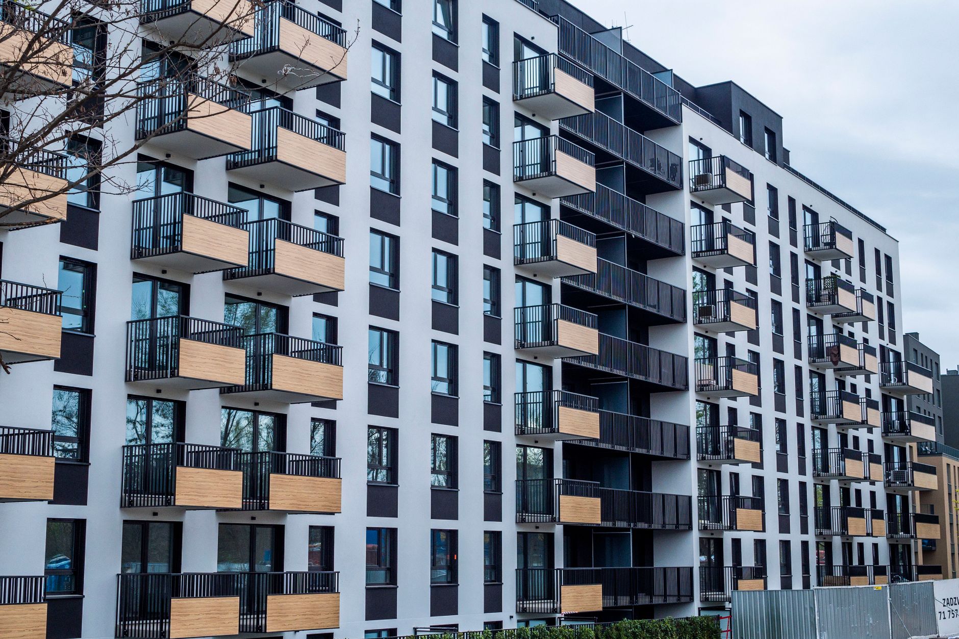 Edifício de apartamentos contemporâneo com varandas em ambiente urbano, apresentando arquitetura moderna.