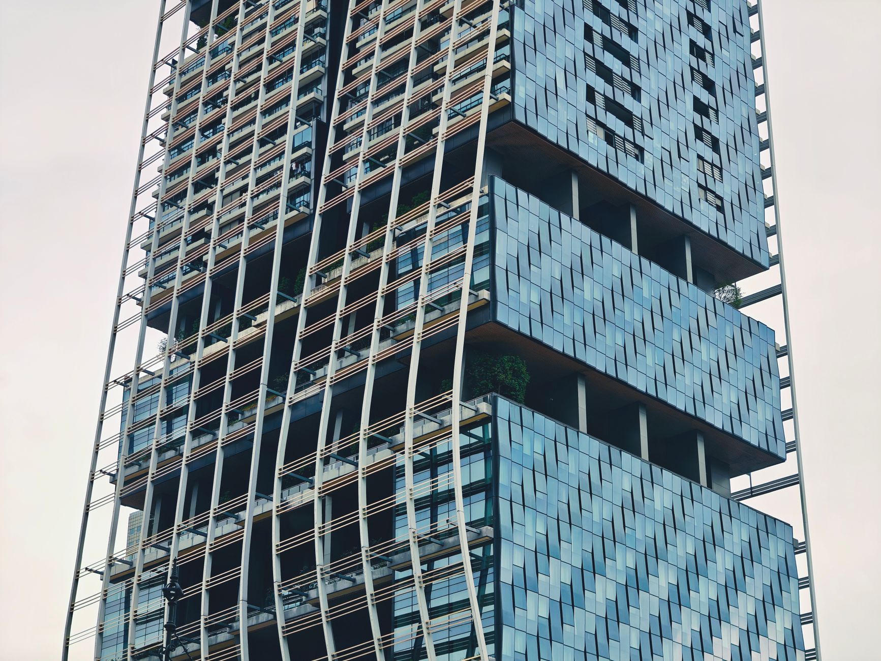 Imagem em close-up de um moderno arranha-céu que exibe arquitetura inovadora no centro de Singapura.